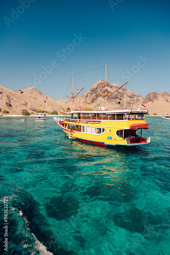 Yellow pinisi heading to pink beach