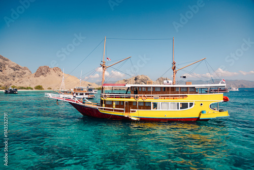 Yellow pinisi with turquoise water