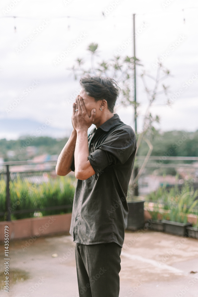 A Southeast Asian man covering his eyes with his hand, A Southeast Asian man covering his eyes with his hand,