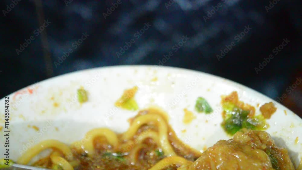 close up of cutting and eating meatballs or pentol with fork and spoon. Bakso in Indonesia traditional food .F