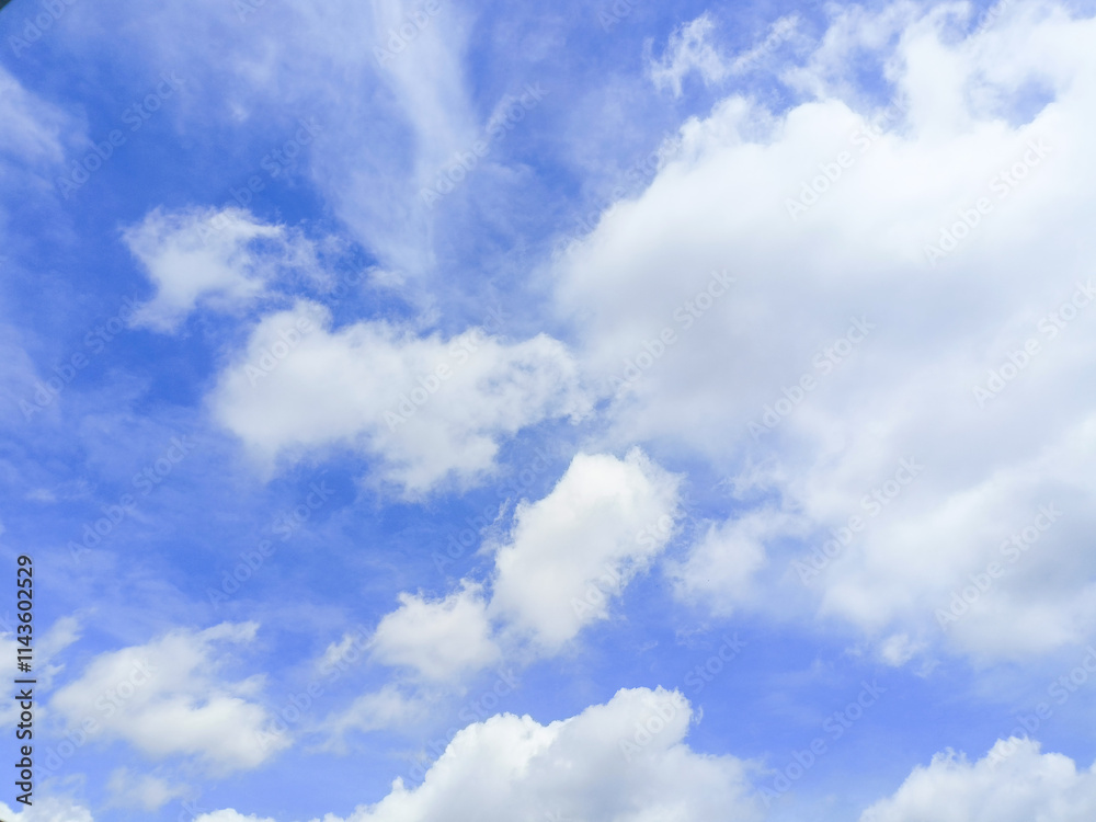 Obraz premium The bright blue sky is decorated with white clouds floating around, creating a beautiful and calming sky view.