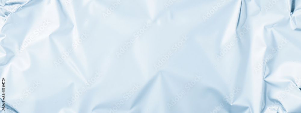 Obraz premium Crumpled light blue foil texture background, smooth metallic surface, soft reflective design, shiny wrinkled pattern, elegant material for modern creative visual