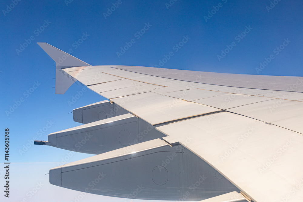 aerial view of airplane wing flying over sky with cloud and clear blue sky atmosphere with sunshine in sunny day, cloudscape from window seat on vacation flight to travel destination aerial view of airplane wing flying over sky with cloud and clear blue sky atmosphere with sunshine in sunny day, cloudscape from window seat on vacation flight to travel destination