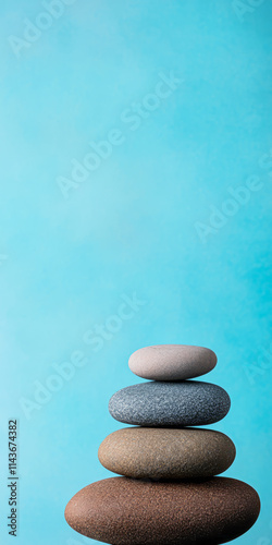 Stacked smooth stones in calming colors against a blue background for relaxation purposes photo