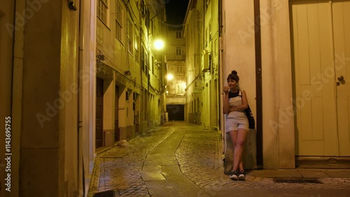 Slow motion of a Latin woman reflecting deeply at night in the streets of Coimbra, Portugal