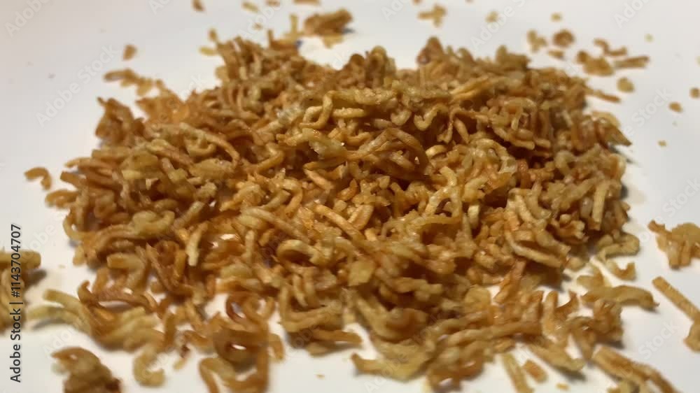 A close-up of crispy, fried noodles on a white plate. A close-up of crispy, fried noodles on a white plate.