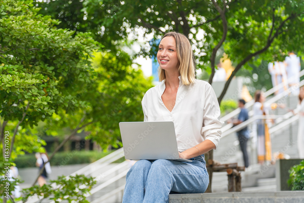 Caucasian Woman Using Laptop to Work While Sitting Outdoor a Park Caucasian Woman Using Laptop to Work While Sitting Outdoor a Park