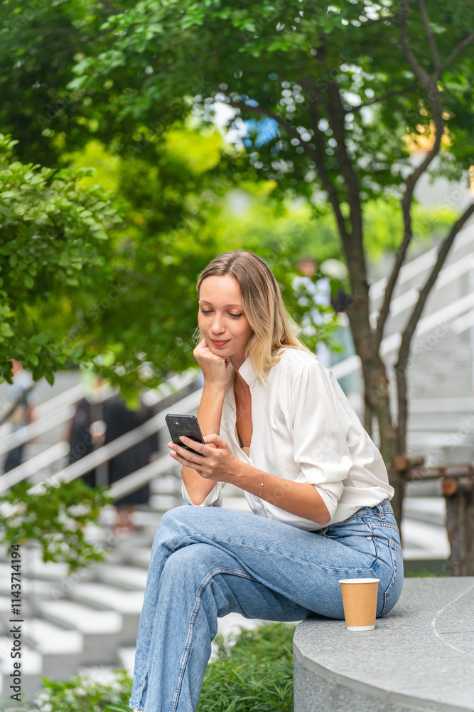 Caucasian Woman Sitting and Using Phone While Having a Cup of Coffee Outdoor a Park Caucasian Woman Sitting and Using Phone While Having a Cup of Coffee Outdoor a Park