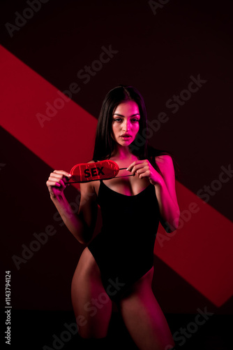 Sensual Woman in a Black Bodysuit With a Sleep Mask, Showcasing a Bold Statement Against a Dark Backdrop