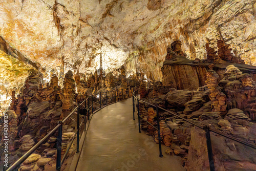 Fotografia Tourists walking on footpath inside postojna cave