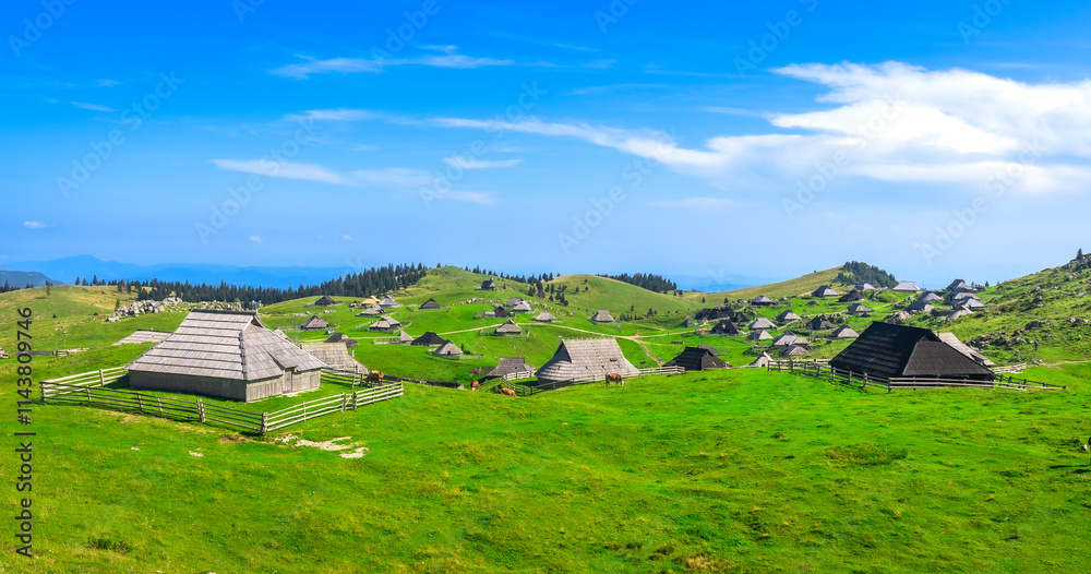 Traditional wooden huts dotting the lush green landscape of velika planina, slovenia Traditional wooden huts dotting the lush green landscape of velika planina, slovenia