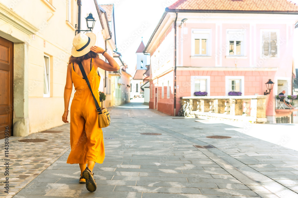Tourist walking in the charming streets of kranj, slovenia, in summer Tourist walking in the charming streets of kranj, slovenia, in summer
