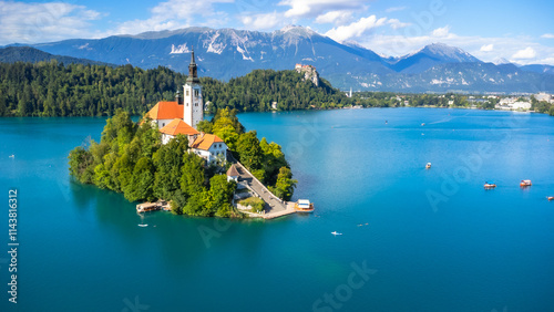Lake bled island church with julian alps in background on sunny summer day