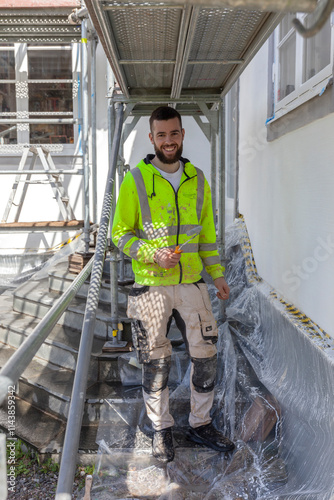 Portrait of smiling worker painting house photo