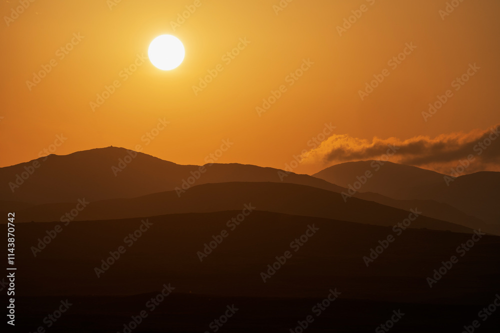 Bright sun over mountains during sunset Bright sun over mountains during sunset