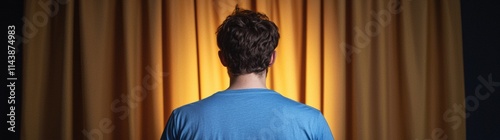 Man standing before curtain back view symmetrical composition