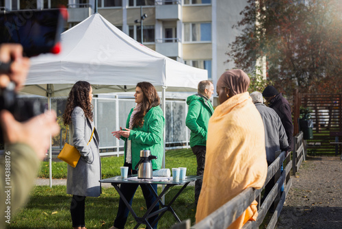 Group of relief workers talking with needy people at park