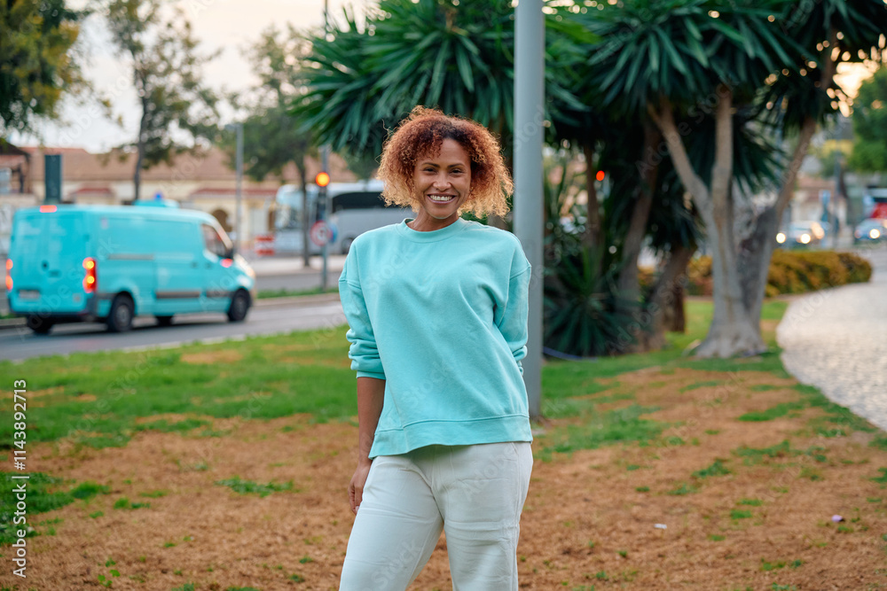 Woman in casual attire enjoys a stroll in the park at sunset in a city Woman in casual attire enjoys a stroll in the park at sunset in a city