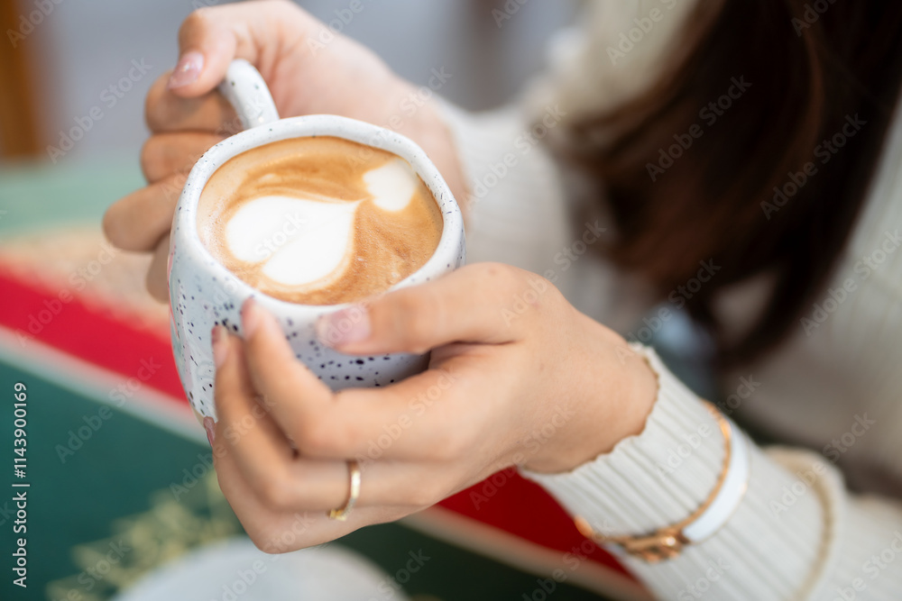 Close-up of hands Holding cup mug of Hot coffee latte decorating to a Christmas tree at home in the living room indoors in coffee shop Decoration During Christmas x-mas and New Year holidays.