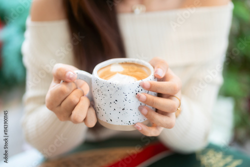 Obraz na płótnie Close-up of hands Holding cup mug of Hot coffee latte decorating to a Christmas tree at home in the living room indoors in coffee shop Decoration During Christmas x-mas and New Year holidays. w salonie