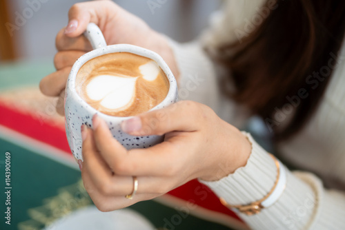 Obraz na płótnie Close-up of hands Holding cup mug of Hot coffee latte decorating to a Christmas tree at home in the living room indoors in coffee shop Decoration During Christmas x-mas and New Year holidays. w salonie