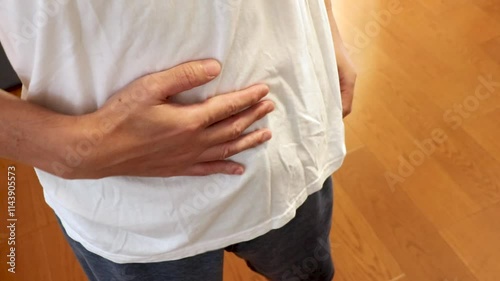 手でお腹を軽く叩く男性