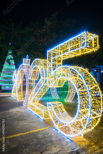 Obraz na płótnie PHITSANULOK, THAILAND - December 15,2024:Decoration lights Christmas tree for celebrate Christmas and New Year Festival 2025 illumination at Saint Nicholas School in Phitsanulok City at night w salonie