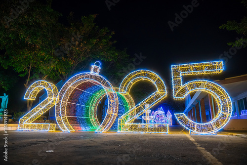 Obraz na płótnie PHITSANULOK, THAILAND - December 15,2024:Decoration lights Christmas tree for celebrate Christmas and New Year Festival 2025 illumination at Saint Nicholas School in Phitsanulok City at night w salonie