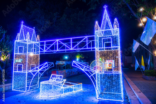 Obraz na płótnie PHITSANULOK, THAILAND - December 15,2024:Decoration lights Christmas tree for celebrate Christmas and New Year Festival 2025 illumination at Saint Nicholas School in Phitsanulok City at night w salonie