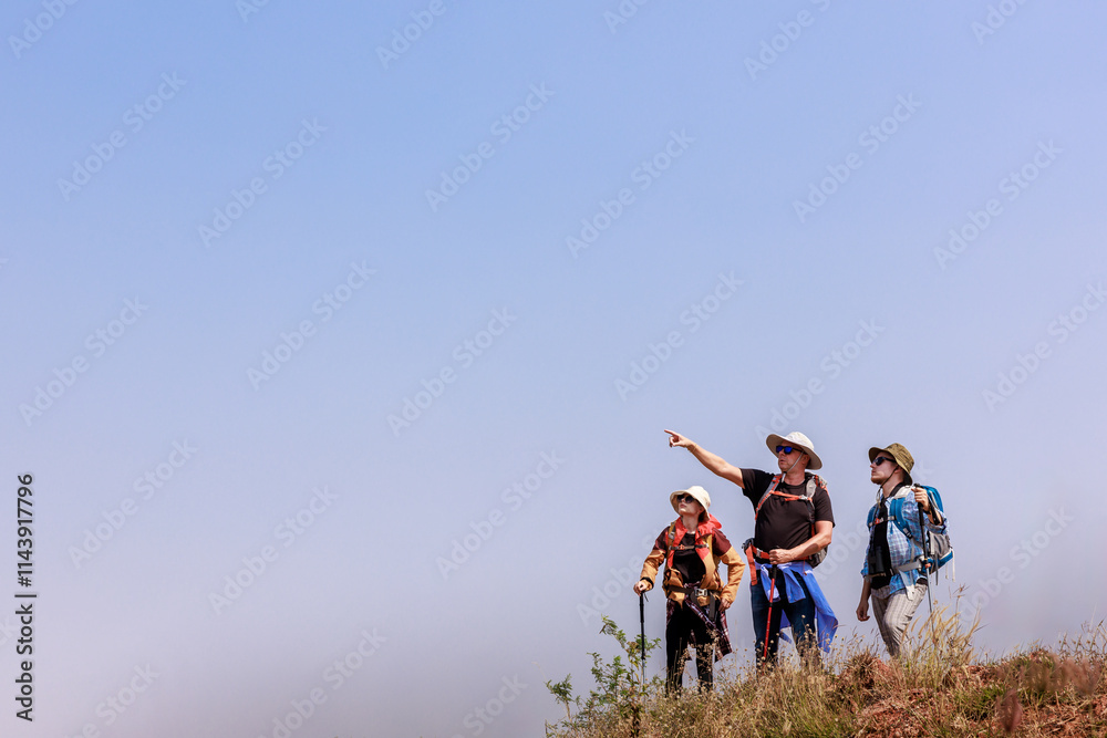 hikers are standing on mountain slope and looking away. hikers are standing on mountain slope and looking away.