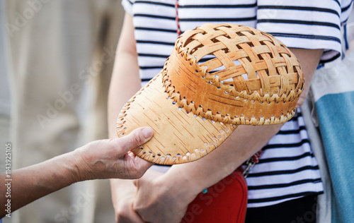 A woman is handing a hat to another woman photo