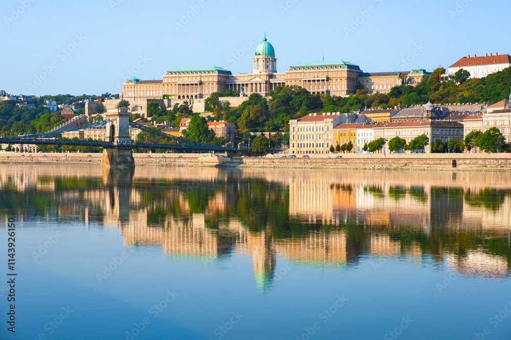 View of Budapest with Buda Castle and the Szechenyi Chain Bridge reflected in the Danube River
