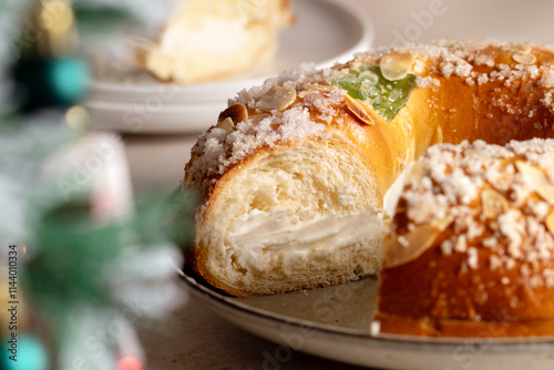 Spanish Three kings cake on decorated table with Christmas tree and burning candles, celebration of Three Kings Day photo