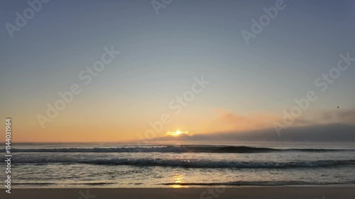 Dawn recorded from the seashore of Varna city beach in Bulgaria, in the Black Sea, with fog over the water in a cold winter morning. Timelapse. 4K photo