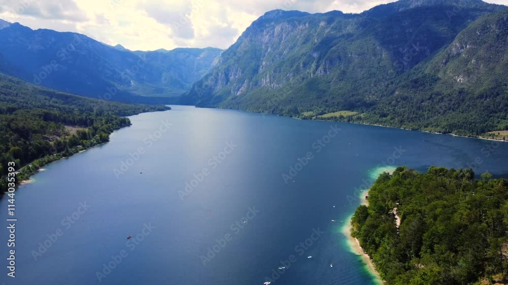 Serene boats glide across the tranquil waters of lake bohinj in slovenia on a stunning summer day Serene boats glide across the tranquil waters of lake bohinj in slovenia on a stunning summer day