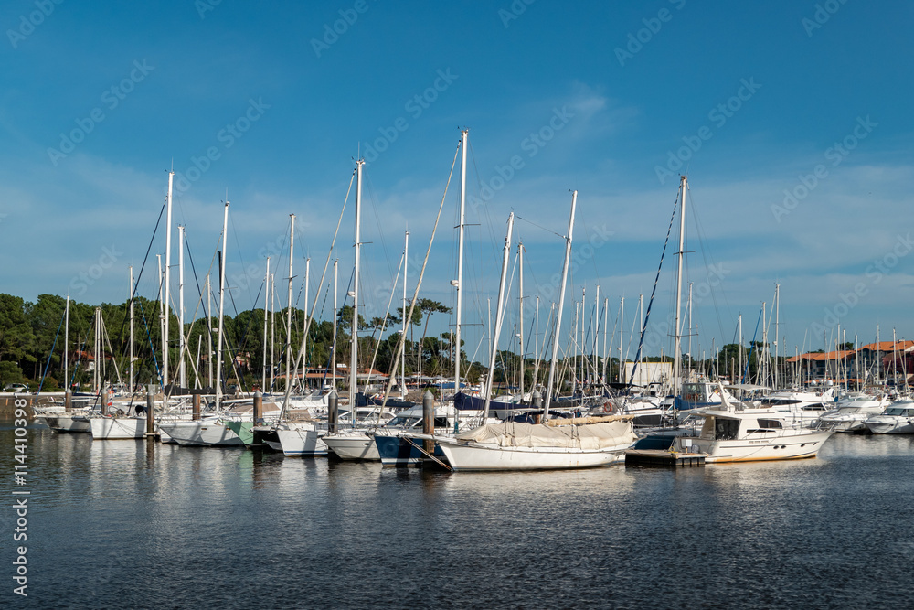 Obraz premium Porto tranquilo de Capbreton no País Basco com barcos ancorados sob um céu azul