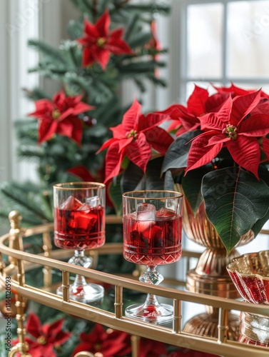 Christmas poinsettia in a red and white color scheme, cocktail glasses on a gold bar cart with red drinks in them, decorated for Christmas. Decorated red glass vases with large green leaves flowers. photo