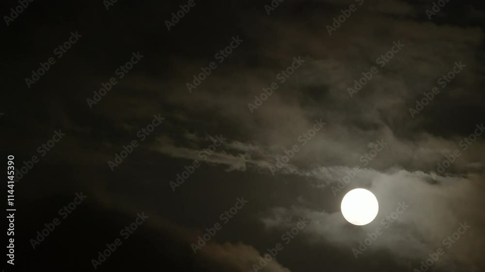 Full Blue Supermoon in the night sky with clouds passing Full Blue Supermoon in the night sky with clouds passing