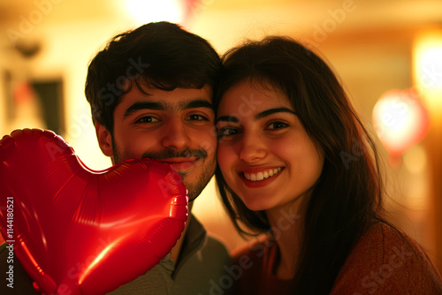 Happy Smiling Couple holding heart shaped red balloons with love, Valentine's day concept