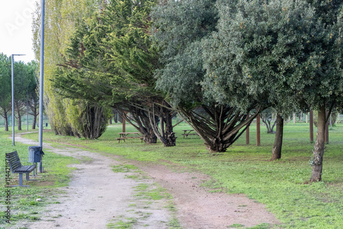 Green park with dirt path, wooden benches and picnic tables inviting to relax in loures, portugal photo