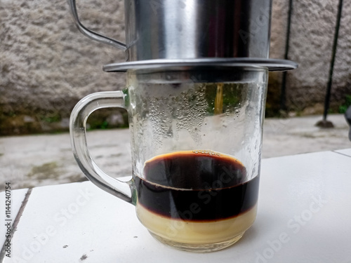 The barista serves coffee with a Vietnam drip coffee maker. Vietnam drip coffee.