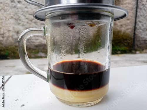 The barista serves coffee with a Vietnam drip coffee maker. Vietnam drip coffee.