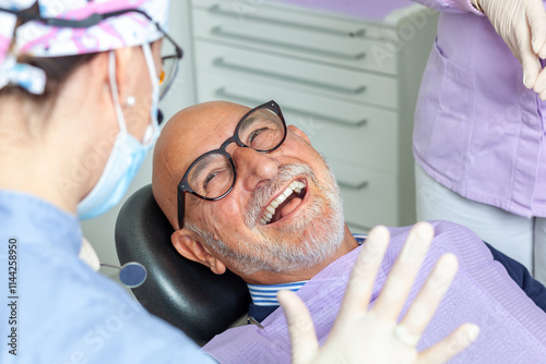 Senior man laughing during dental checkup at clinic