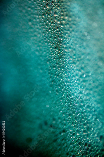 Close Up of Condensation Floating Liquid Water Bubbles and Drips on Glass from Rain