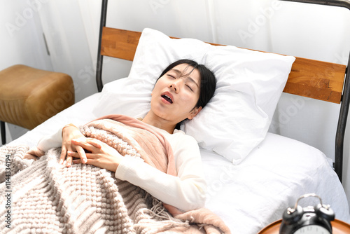 ベッドの上でいびきをかき寝るアジア人女性 photo