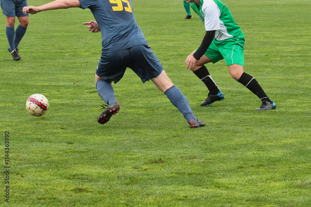 One attacking soccer player in a blue uniform, dribbling the ball and kicking it during a match at the stadium One attacking soccer player in a blue uniform, dribbling the ball and kicking it during a match at the stadium