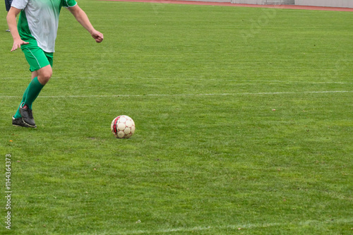 An attacking soccer player speeds up to take a penalty shot, an eleven-meter kick in soccer.