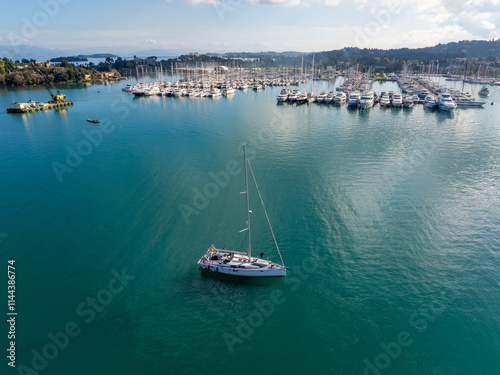 Sailboat near marina on turquoise water under blue sky photo