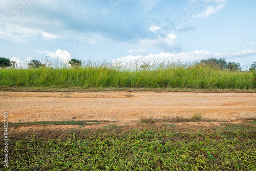 Landscape of gravel road in countryside with blue sky. Road in rainy season. Side view of dirt road on top mountain. road background.