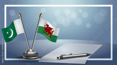Pakistan and Wales National flags on small table with bokeh background, cooperative relationship